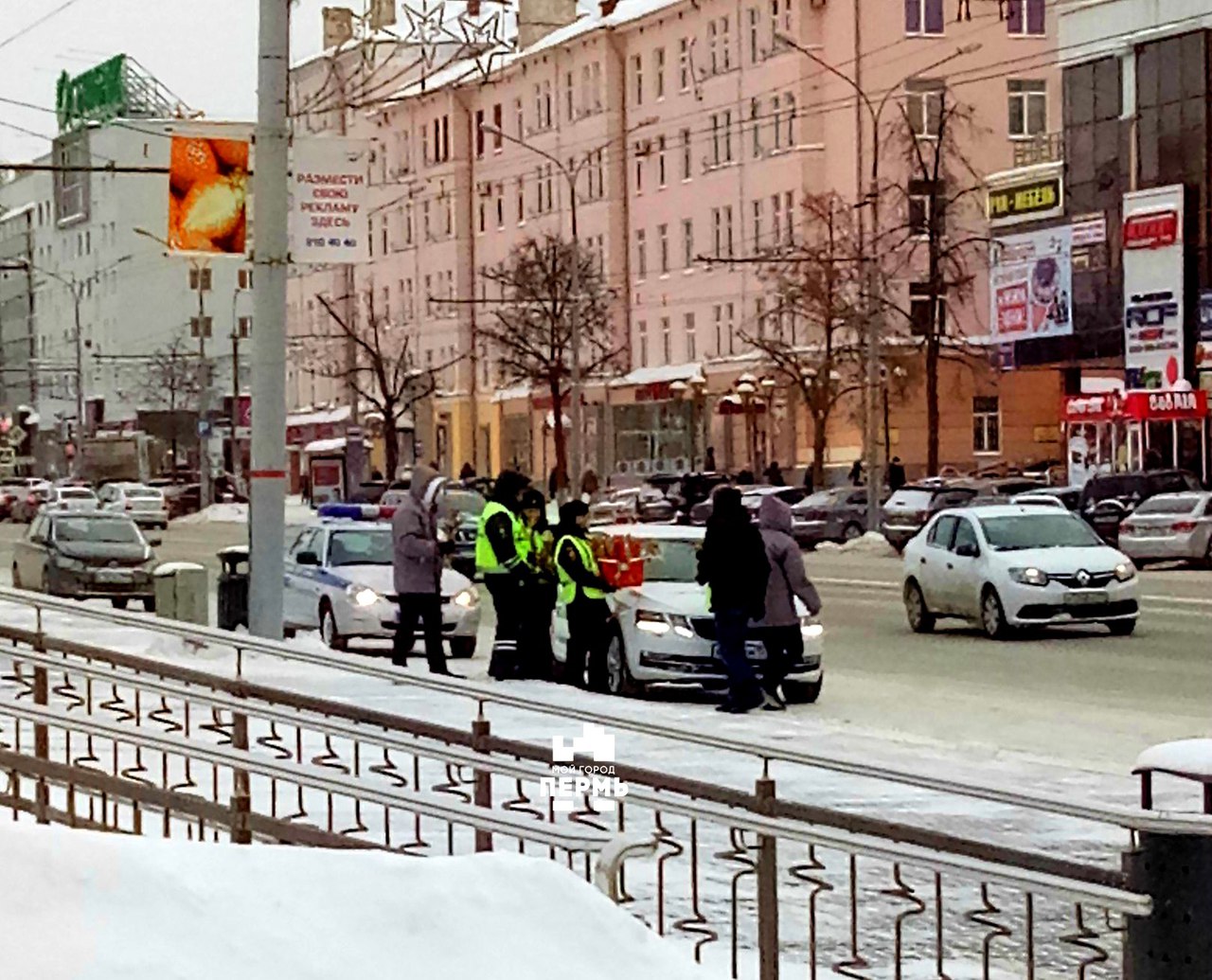 Сотрудники ДПС дарят цветы девушкам-водителям около Драмтеатра.